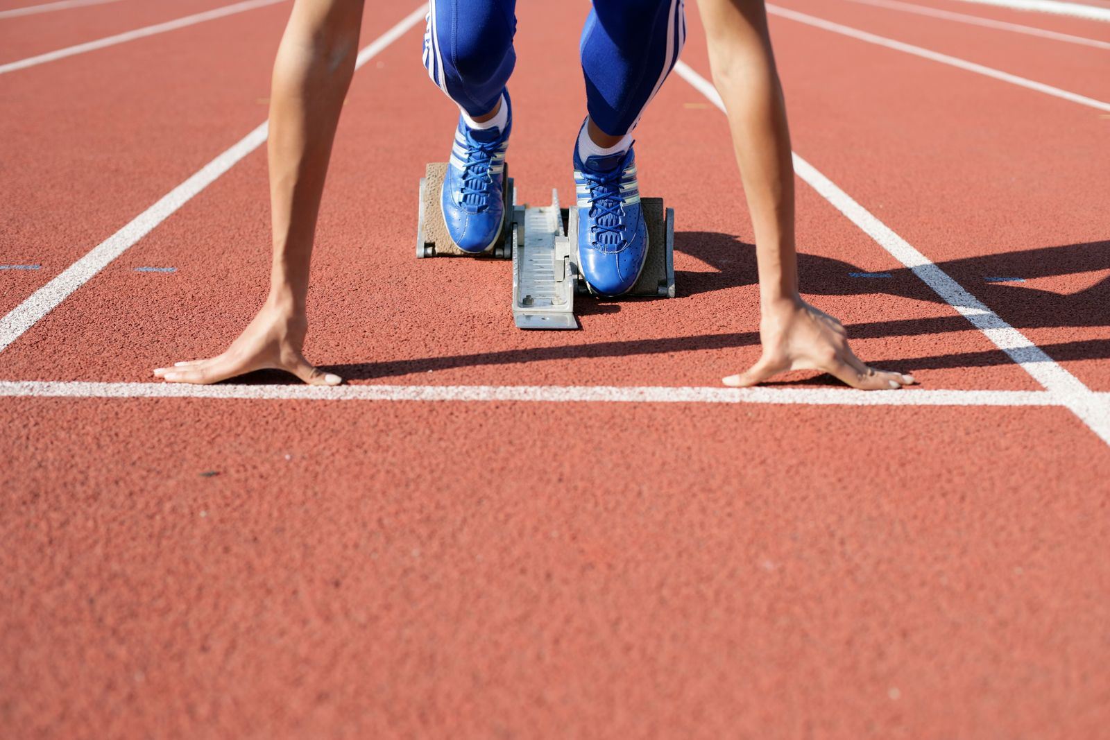 Athlète en position de départ de sprint dans les starting-blocks